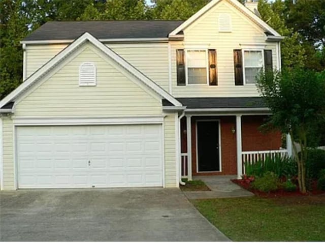 view of property with covered porch and a garage