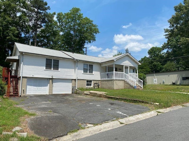 split foyer home with covered porch, a front yard, and a garage