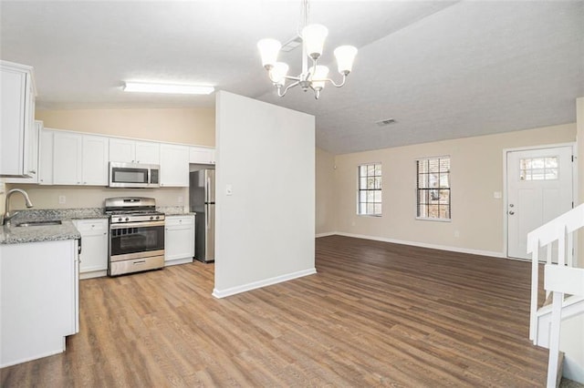 kitchen with sink, a chandelier, pendant lighting, white cabinets, and appliances with stainless steel finishes