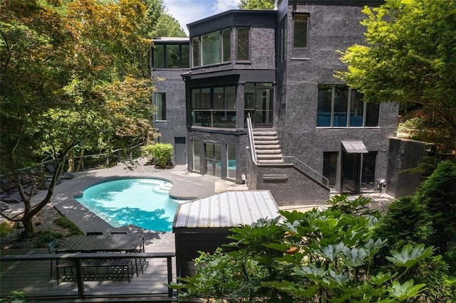 4 W Wesley Rdg NW, Atlanta, GA 30327 - rear view of property with stairway, stucco siding, a sunroom, a patio, and an outdoor pool