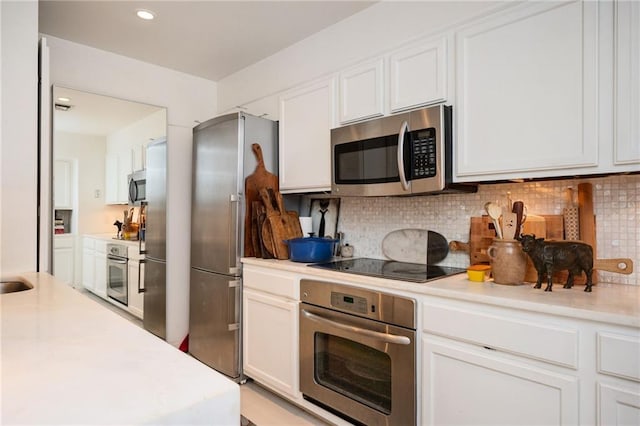 145 15th St NE Unit 1225, Atlanta, GA 30309 - kitchen featuring appliances with stainless steel finishes, light countertops, white cabinets, decorative backsplash, and recessed lighting