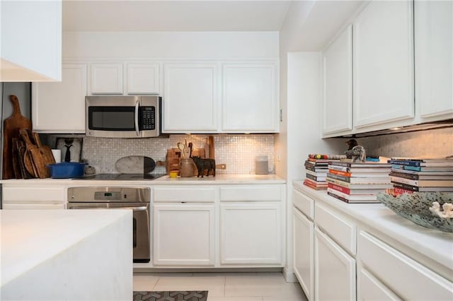 145 15th St NE Unit 1225, Atlanta, GA 30309 - kitchen with stainless steel appliances, white cabinetry, light countertops, backsplash, and light tile patterned flooring