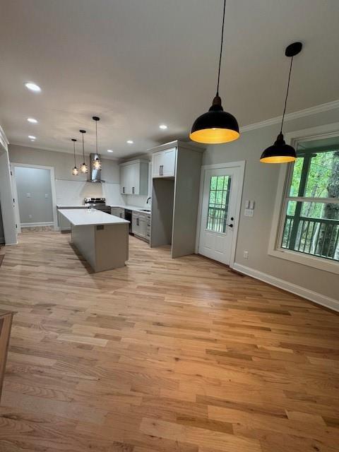 1713 Cagle Ct, Lawrenceville, GA 30045 - kitchen with crown molding, baseboards, light wood finished floors, a center island, and recessed lighting