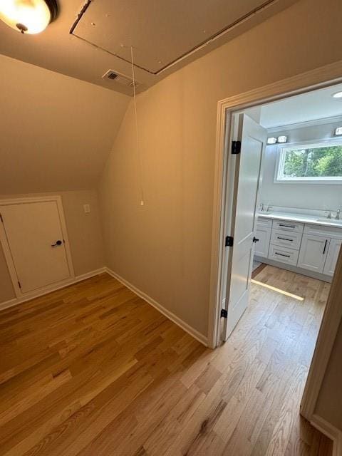 1713 Cagle Ct, Lawrenceville, GA 30045 - additional living space with attic access, light wood-style flooring, a sink, vaulted ceiling, and baseboards