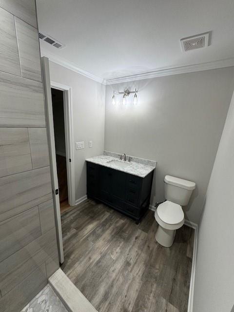1713 Cagle Ct, Lawrenceville, GA 30045 - bathroom with wood finished floors, crown molding, toilet, vanity, and baseboards