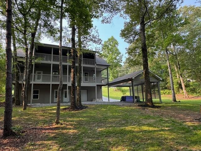 1713 Cagle Ct, Lawrenceville, GA 30045 - back of property featuring a yard, a carport, and a balcony