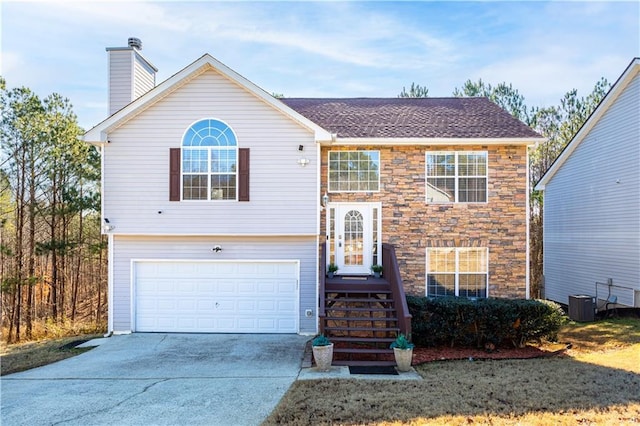 split foyer home featuring central AC and a garage