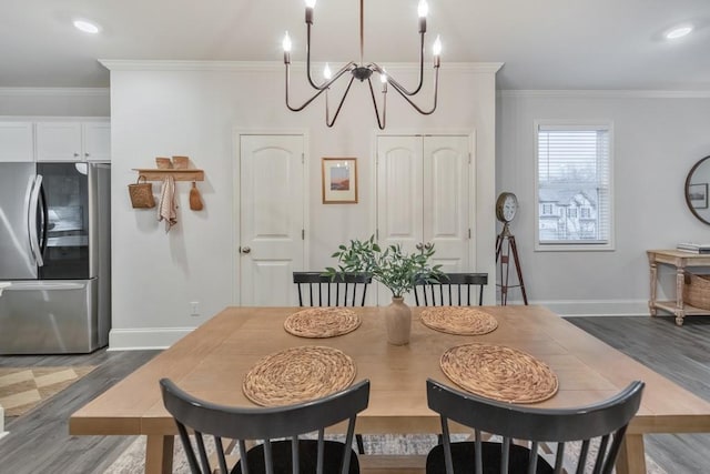 dining area with ornamental molding, dark hardwood / wood-style floors, and a notable chandelier