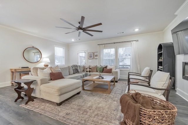 living room with hardwood / wood-style floors, a wealth of natural light, and ornamental molding