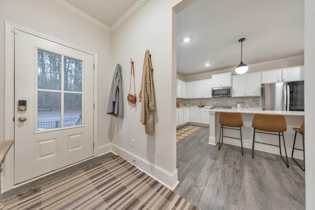 entryway featuring light hardwood / wood-style flooring and ornamental molding