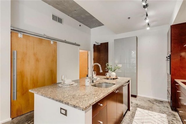 kitchen with visible vents, wall oven, an island with sink, a sink, and dishwasher