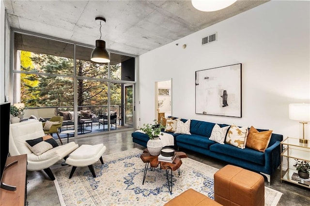 living room featuring finished concrete floors, visible vents, and expansive windows