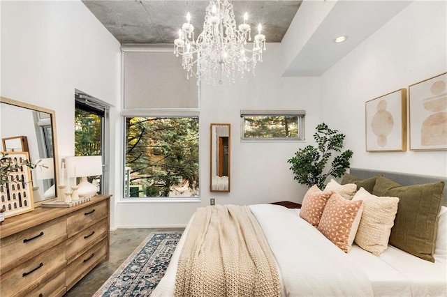 bedroom featuring finished concrete flooring, a high ceiling, and a notable chandelier