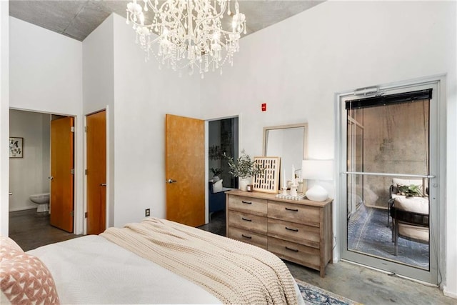 bedroom featuring concrete flooring, a high ceiling, a notable chandelier, and ensuite bath