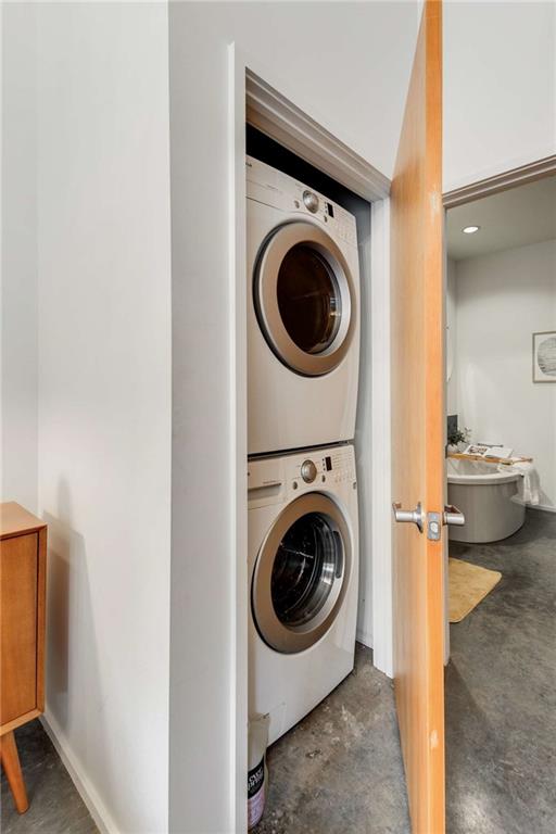 laundry area featuring stacked washer / drying machine and laundry area