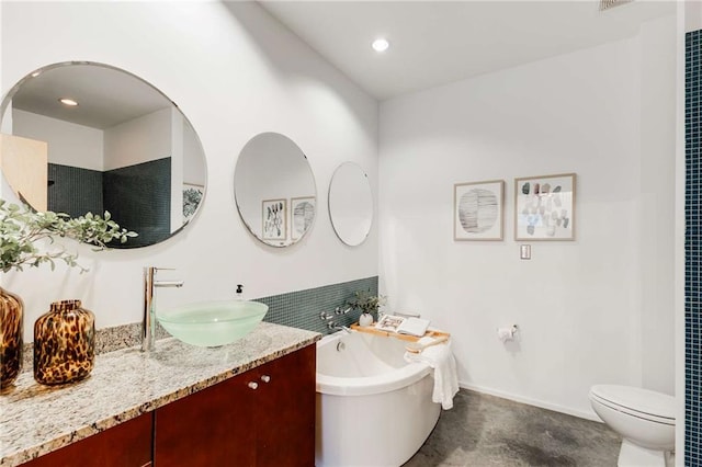 full bath featuring recessed lighting, vanity, a soaking tub, and toilet
