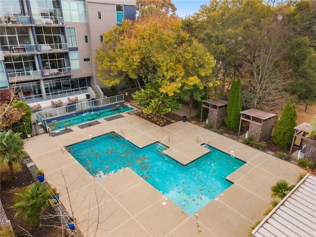community pool with fence and a patio