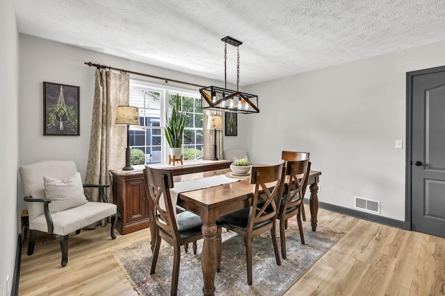 6127 Yellow Creek Rd, Murrayville, GA 30564 - dining space with a chandelier, light wood finished floors, a textured ceiling, and baseboards