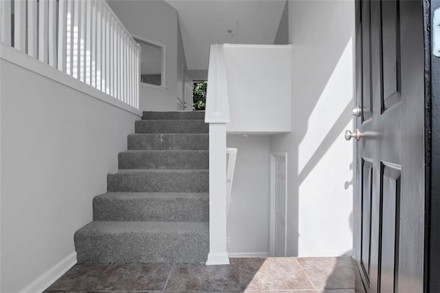 stairway featuring a towering ceiling