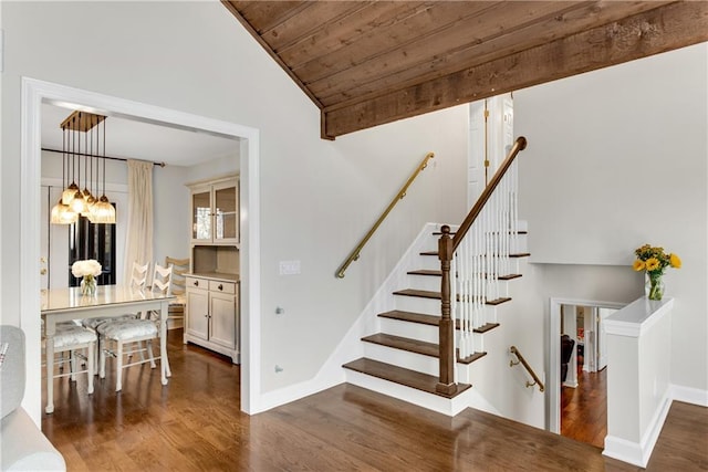 stairs with vaulted ceiling, wood ceiling, wood finished floors, and baseboards