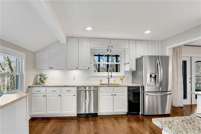 kitchen with dark wood-style flooring, stainless steel appliances, lofted ceiling with beams, and a sink