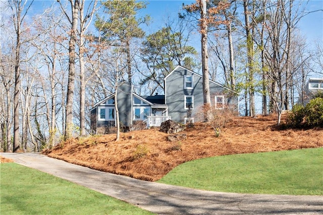 view of front facade featuring a chimney and a front yard