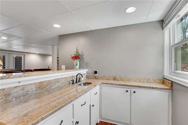 bathroom with a drop ceiling, recessed lighting, and a sink