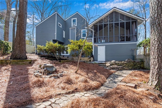 rear view of house featuring a sunroom