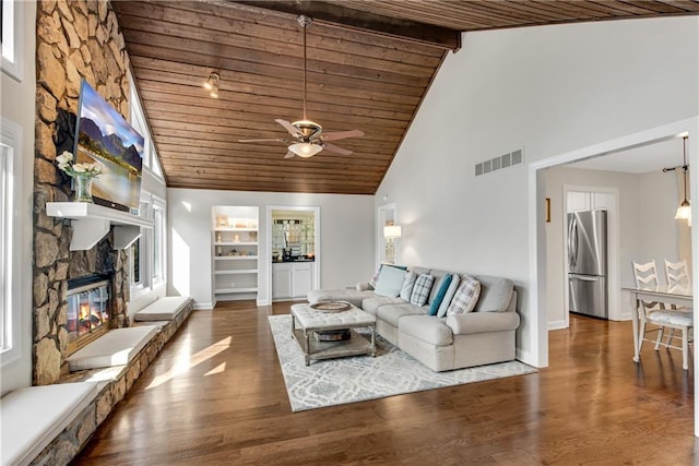 living room with a fireplace, wood ceiling, wood finished floors, and visible vents