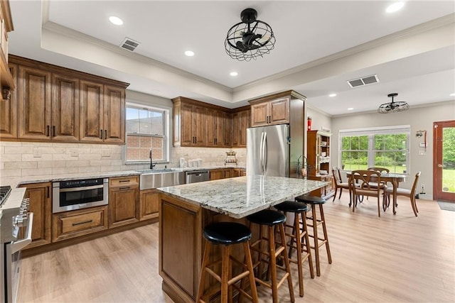 kitchen with light stone countertops, visible vents, appliances with stainless steel finishes, and a sink