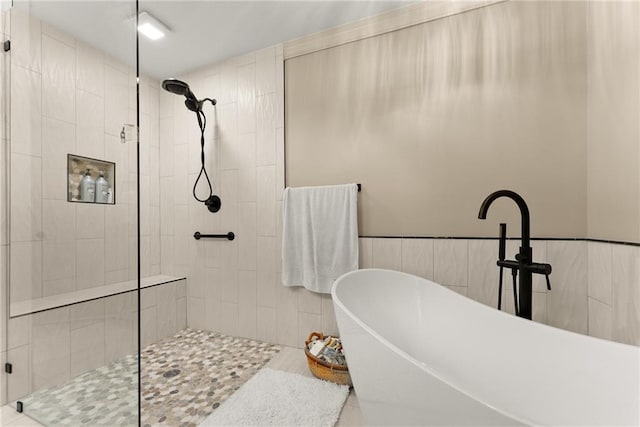 full bathroom featuring a stall shower and a freestanding bath