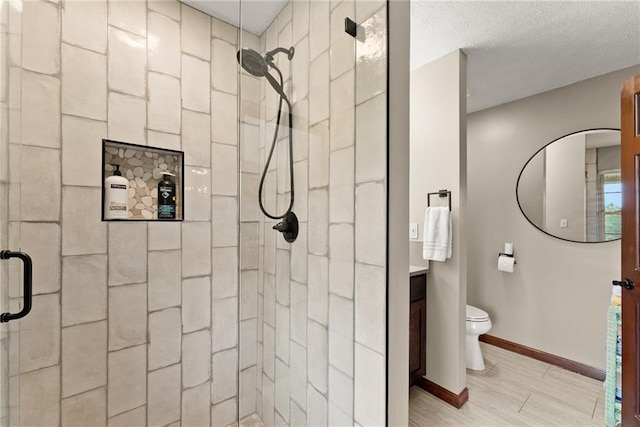 full bathroom with toilet, wood finished floors, vanity, baseboards, and a stall shower