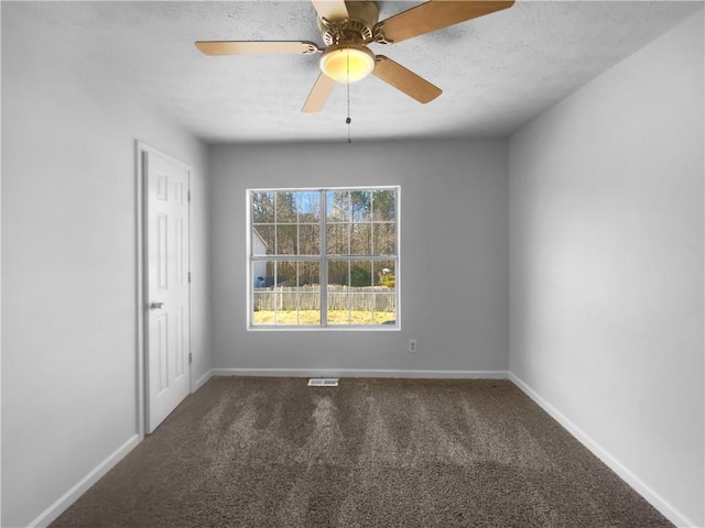 spare room with a ceiling fan, carpet, visible vents, and baseboards