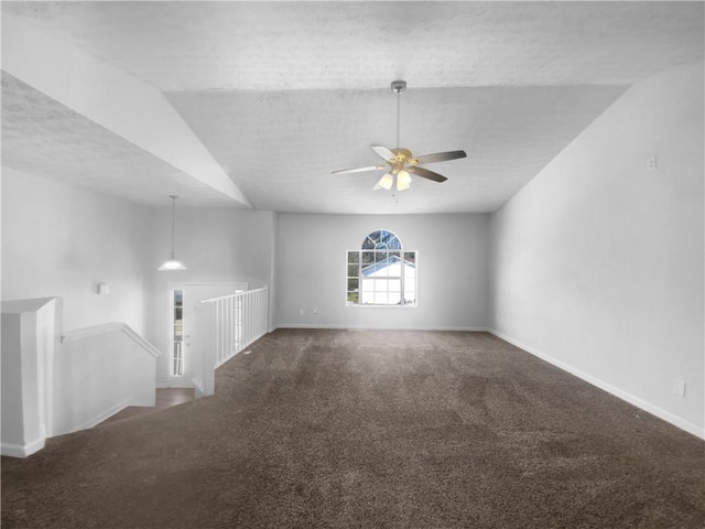 unfurnished living room featuring vaulted ceiling, carpet flooring, a ceiling fan, and baseboards