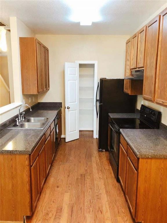301 Brookview Dr, Riverdale, GA 30274 - kitchen with black electric range, dark countertops, light wood-style flooring, ventilation hood, and brown cabinetry