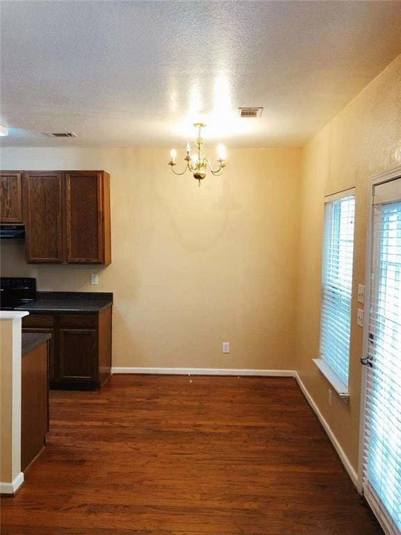 301 Brookview Dr, Riverdale, GA 30274 - kitchen with range hood, a chandelier, dark wood-style flooring, stove, and dark countertops