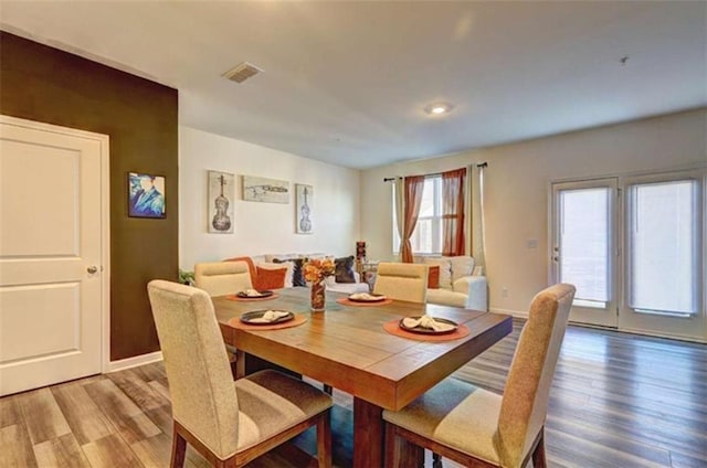 dining space featuring visible vents, light wood-type flooring, and baseboards