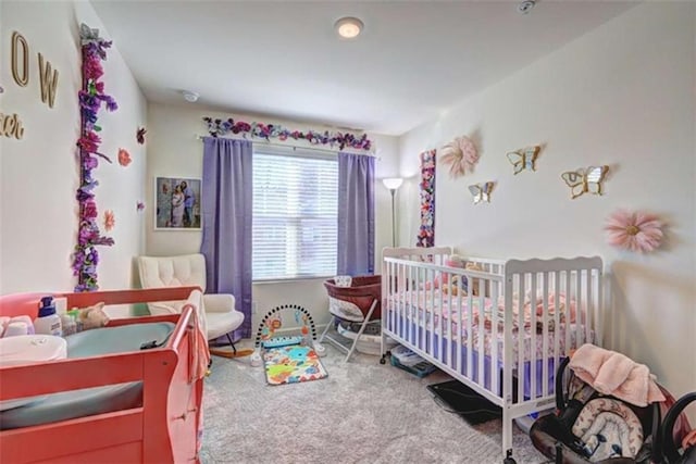 bedroom featuring a crib and carpet