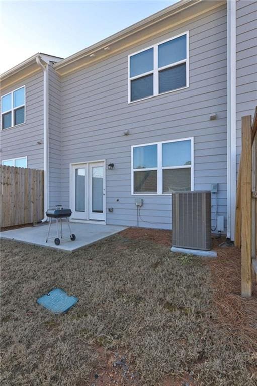 rear view of house featuring a patio area, central air condition unit, and fence