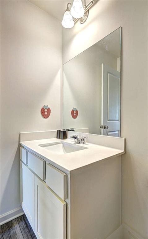 bathroom with vanity, baseboards, and wood finished floors