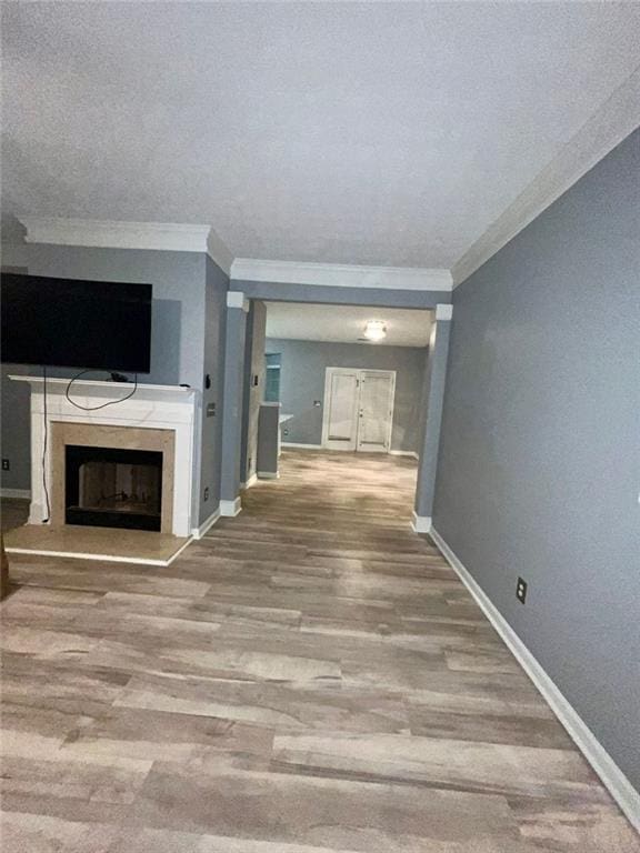 unfurnished living room with crown molding and hardwood / wood-style floors