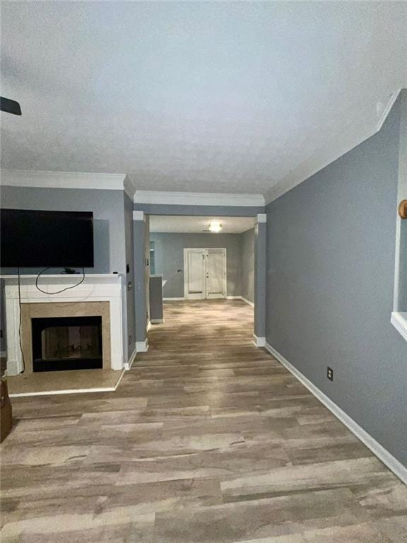 unfurnished living room with hardwood / wood-style flooring, a textured ceiling, and ornamental molding