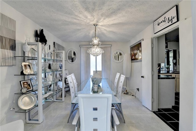 tiled dining area with a notable chandelier and a textured ceiling