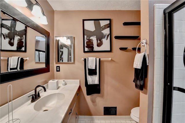 bathroom with walk in shower, tile patterned flooring, a textured ceiling, toilet, and vanity