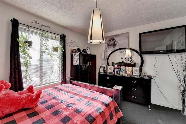 bedroom featuring dark carpet and a textured ceiling