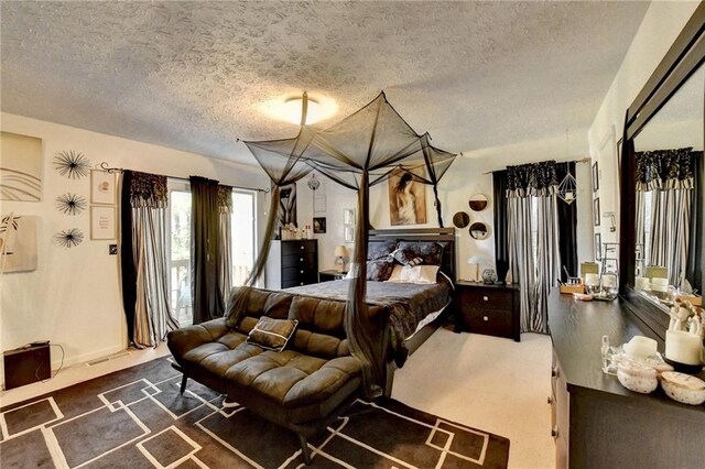 bedroom with carpet and a textured ceiling