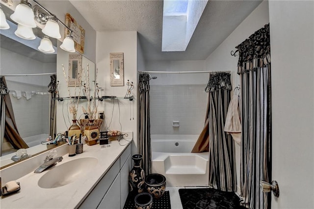 bathroom with a skylight, shower / bath combo, tile patterned flooring, a textured ceiling, and vanity