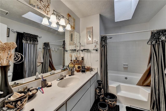 bathroom featuring vanity, a textured ceiling, shower / tub combo, and a skylight