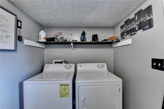 laundry room with a textured ceiling and washing machine and dryer