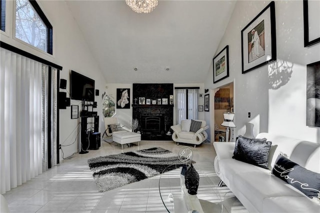 tiled living room with a notable chandelier, a large fireplace, and high vaulted ceiling